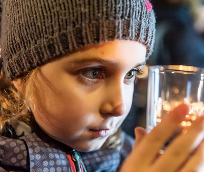 Ein Mädchen begutachtet ein leuchtendes Weihnachts-Souvenir