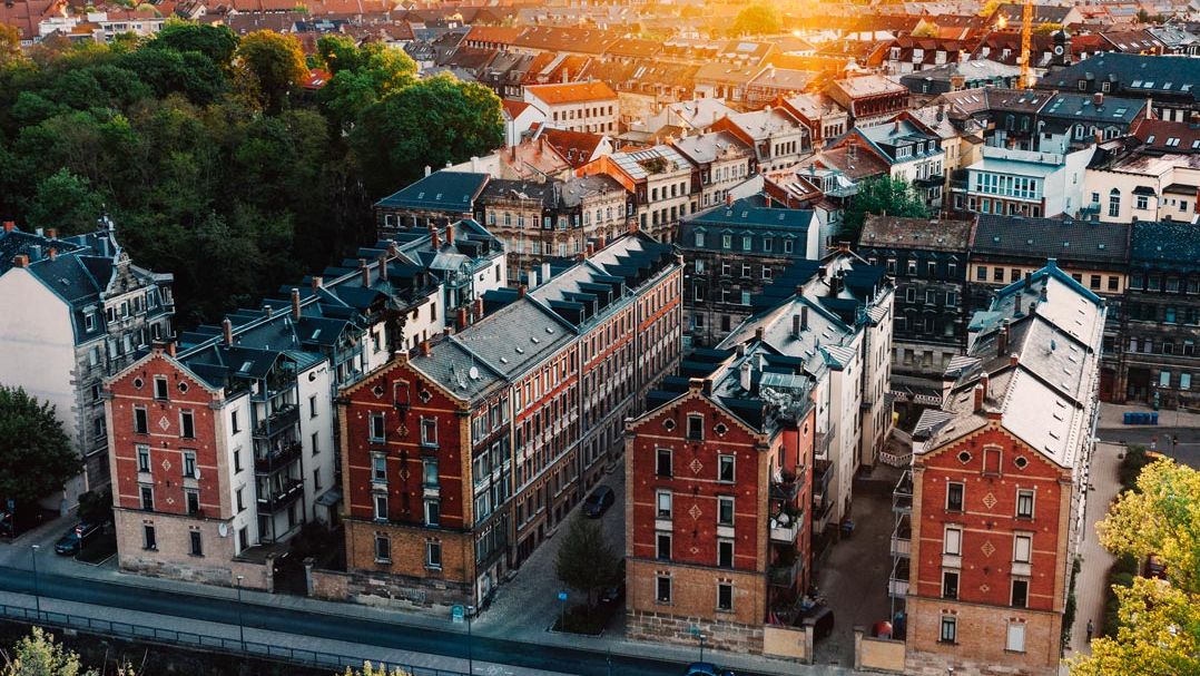 Blick von oben auf die Kißkalt'schen Häuser an der Uferpromenade bei Sonnenaufgang. Im Hintergrund der Rathausturm und der Kirchturm von Sankt Michael.