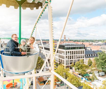 In the big wheel at the Michaelis Kirchweih Fair A family in the big wheel at the Michaelis Kirchweih Fair. In the background there is a nice view over Fürth and the city hall
