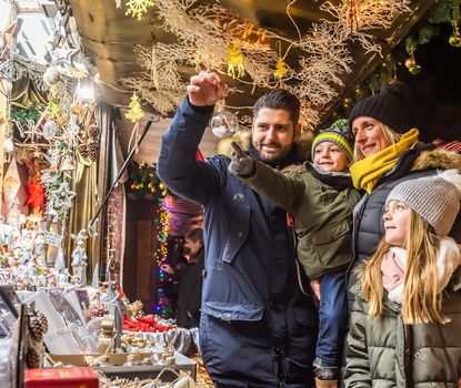 Eine Familie begutachtet Weihnachtsschmuck