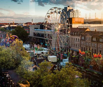 Michaelis-Kirchweih Blick von oben auf die Michaelis-Kirchweih auf der Fürther Freiheit. In der Abendstimmung ist das Riesenrad im Vordergrund zu sehen.