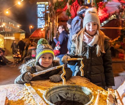 Zwei Kinder gießen ihre eigenen Kerzen am Fürther Mittelaltermarkt