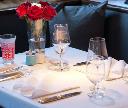 Gedeckter Tisch in der Kupferpfanne Gedeckter Tisch mit roten Rosen im Restaurant Kupferpfanne