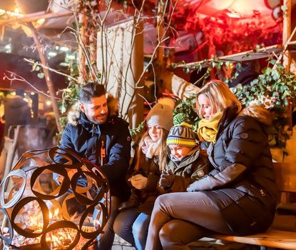 Eine Familie sitzt vor einer Feuerschale