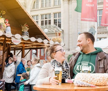 Michaelis-Kirchweih fair A happy couple drinking beer in the fore of the municipal theatre at the Michaelis Kirchweih fair